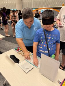 A young visitor is attempting to solve a puzzle while blindfolded