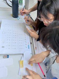 A group of visitors at iC2 booth collaborated to decode quotes using the Unified English Braille (UEB) chart