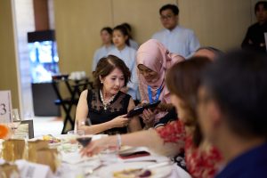 An iC2 staff assisting a winning bidder